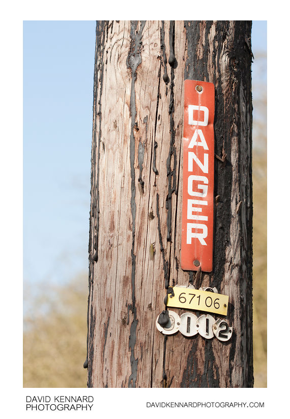 Danger sign on wooden pole