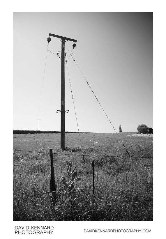 Electricity pole in field