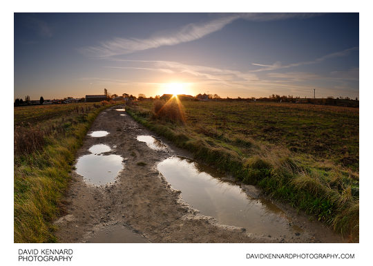 Sunrise over a puddle filled track across Farndon Fields