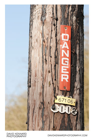 Danger sign on wooden pole