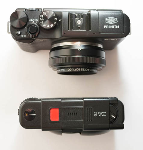 Fuji X-A1 Mirrorless Camera with Fuji 27mm f/2.8 lens compared in size to Olympus XA 2 compact 35mm film camera (top down view)