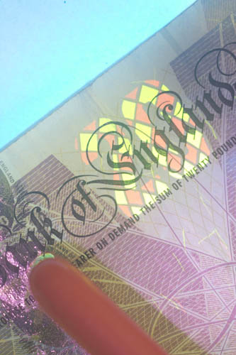 Visible light photo of a British £20 bank note with UV induced fluorescence lit using Convoy S2+ Nicha 365nm UV torch with glass protector in place