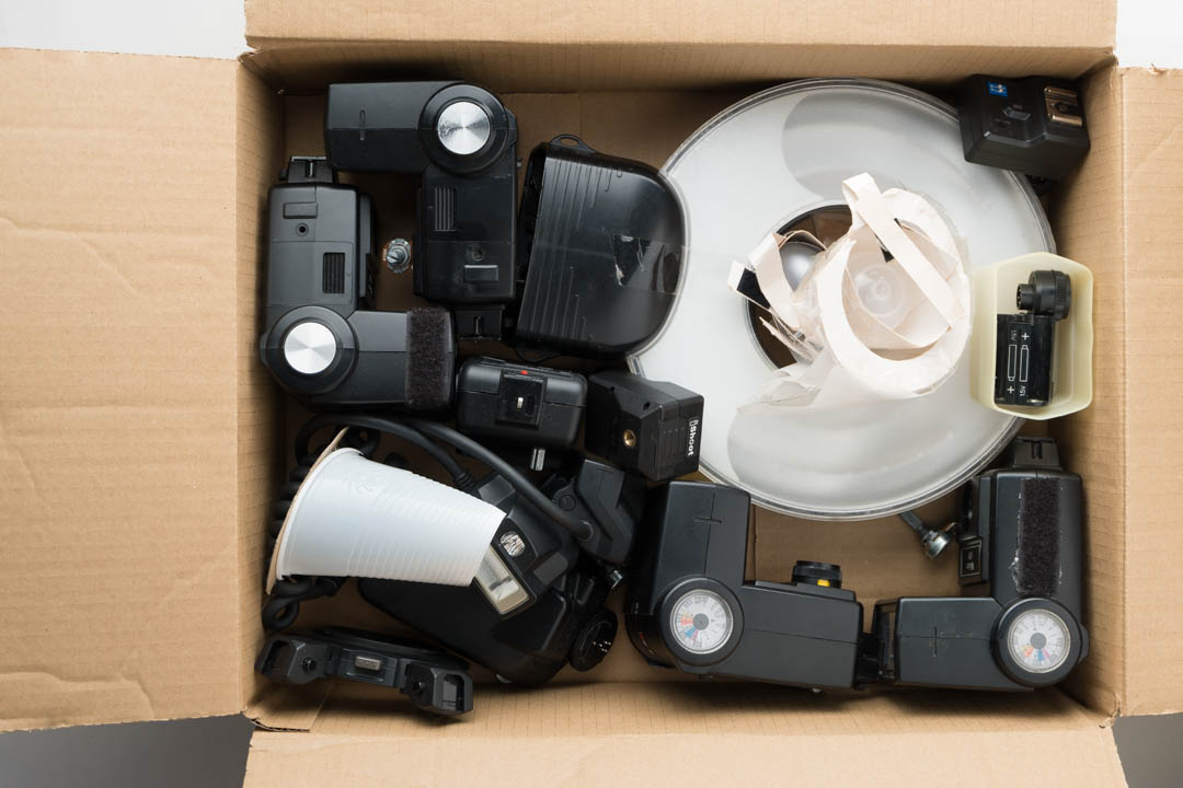 Speedlight flashes, Ringflash adapter, and macro twin-light with diffusers in cardboard box