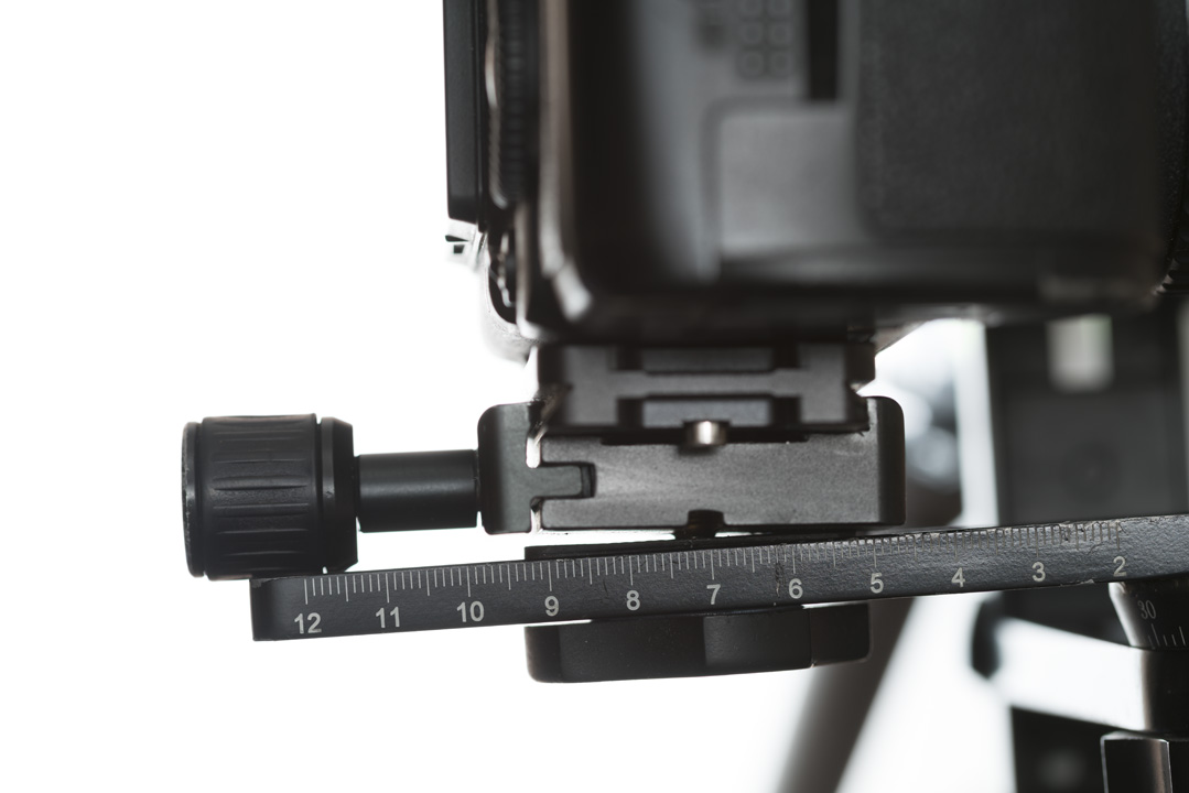 Camera with L-plate attached to generic standard arca-swiss compatible QR clamp mounted on pano head arm. The clamp is not mounted correctly because the knob is too large.