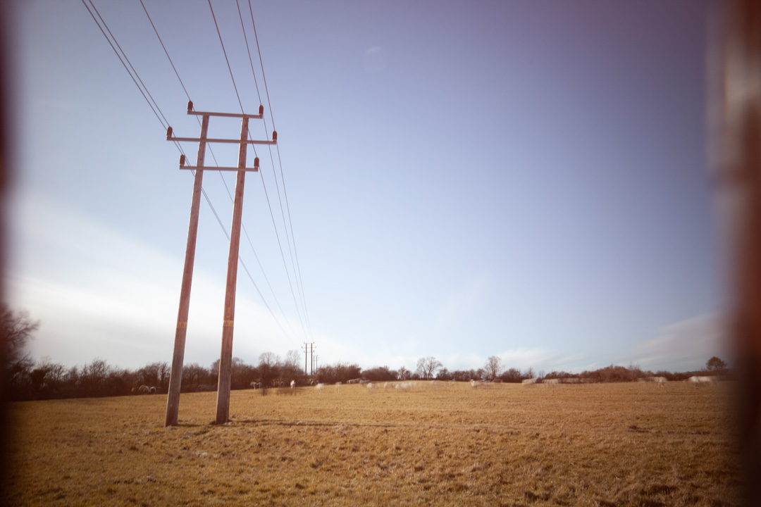 Photo of power lines crossing a field taken on a standard Canon 5D Mark II camera with Schott BG40 IR cut filter, XCSource 10 stop glass ND filter and Hitech 1, 2, and 3 stop plastic ND filters