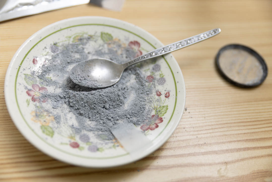 Saucer of grey PTFE powder made by mixing white PTFE powder and carbon powder