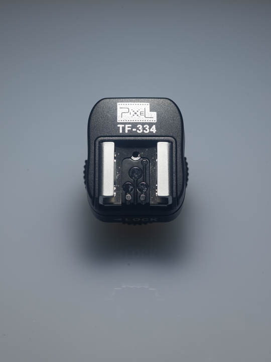 Photo of the shoe of the Pixel TF-334 flash adapter, showing the pads for connecting to the trigger and TTL communication pins of Canon and Nikons speedlight flashes.