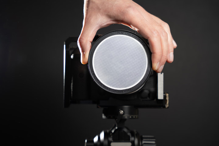 Holding expodisc over camera lens to take a flat image