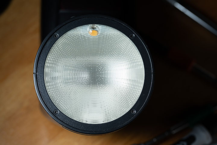Front of the Godox V1 showing the retaining ring with 4 screws