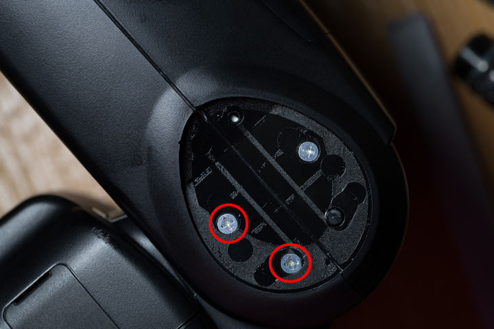 Godox V860II flash with rubber cover removed from the side of the hinge, revealing screws