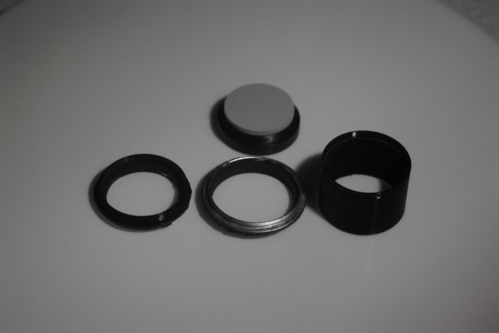 Photo of filter rings after painting with Black 2.0 paint and an unpainted 3D printed PTEG lens hood, shot in near infrared (850nm+) with a white background