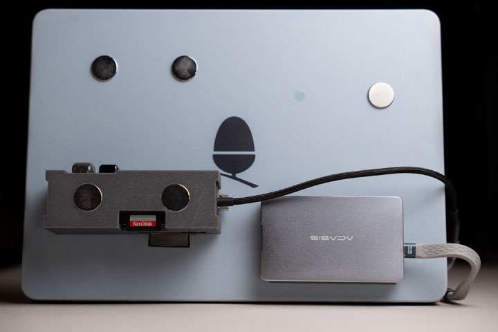Laptop lid cover with magnets glued on and devices attached using 3D printed cases that incorporate magnets