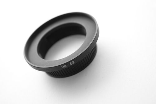 Step up ring screwed into the cut out end of the rear lens cap